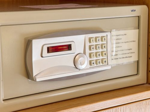 Elektronischer Safe mit Zahlenschloss Display und Bedienungsanleitung in einem Holzregal