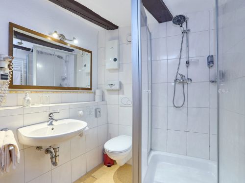 Modernes Badezimmer mit Dusche Toilette Waschbecken großem Spiegel und Handtüchern