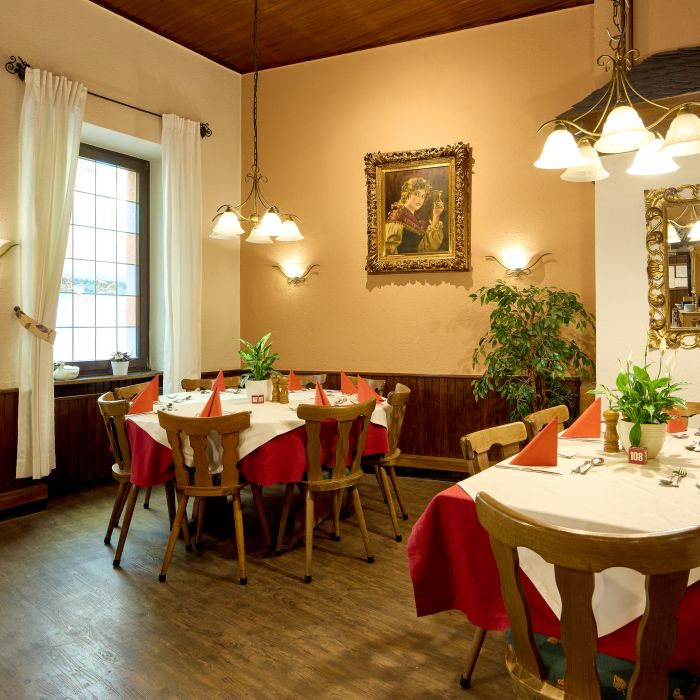 Gemütliches Restaurant mit Holzmöbeln rot weißen Tischdecken und dekorierten Fenstern und Wänden